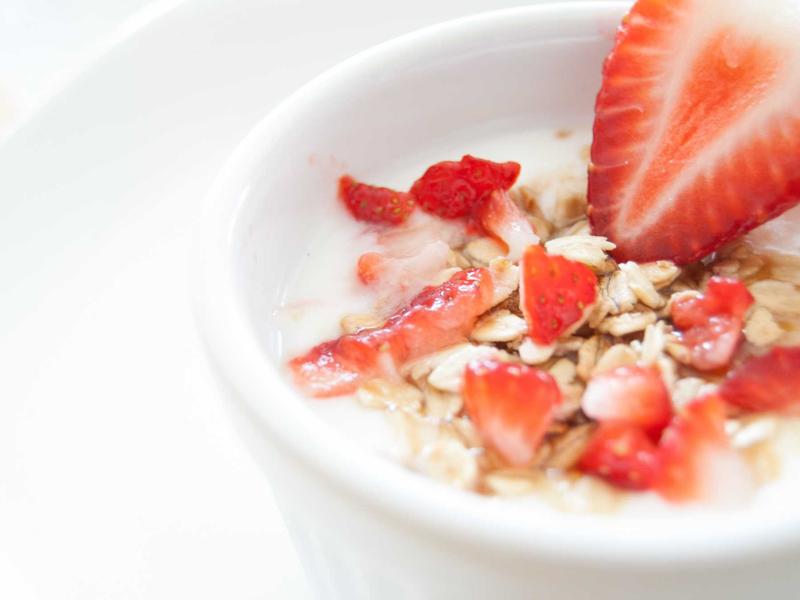 Bowl of yoghurt topped with strawberries and granola