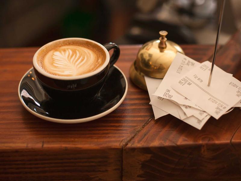 Latte with leaf latte art on a wooden tray