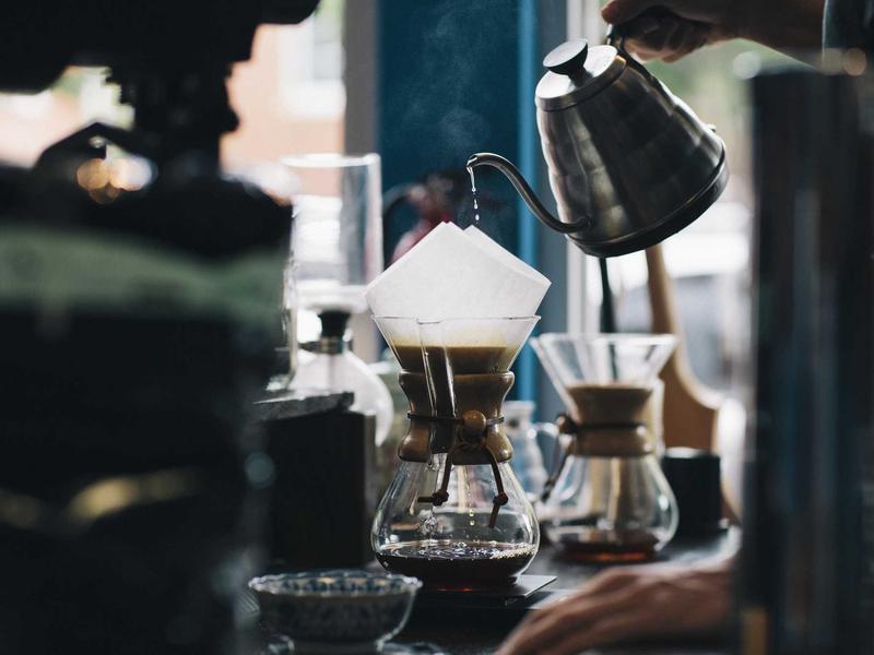 Pour-over coffee being brewed by hand on the bar