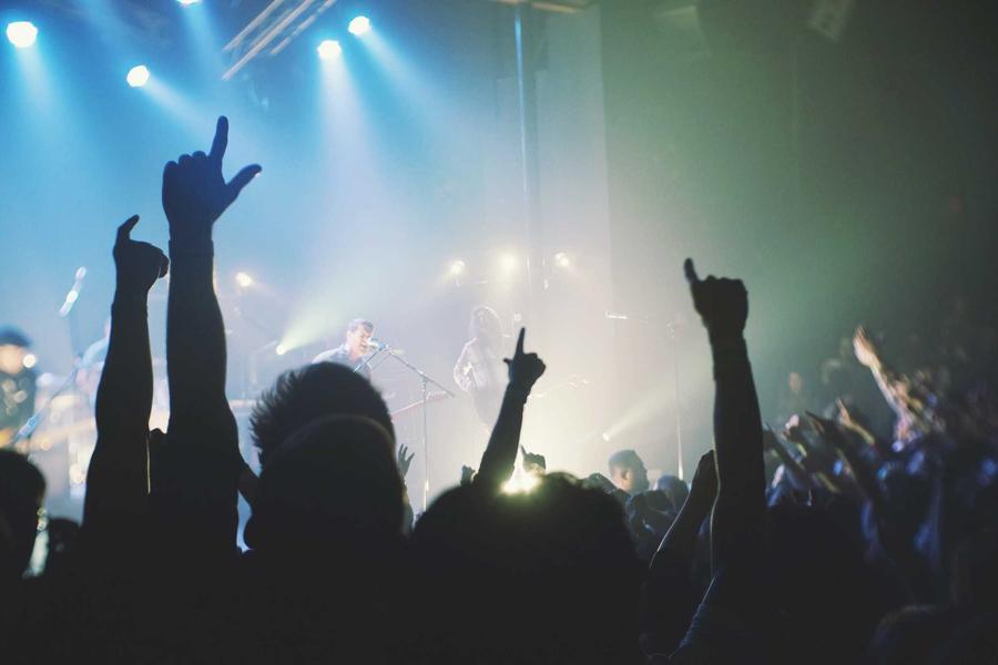 Hands in the air under blue club lights
