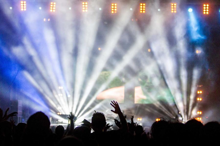 Stage lights beaming over a crowd